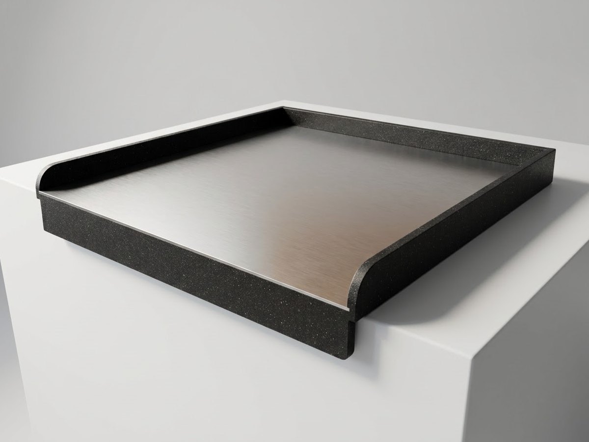 Stendì on a plain white block: black frame, steel surface and the lip over the front edge