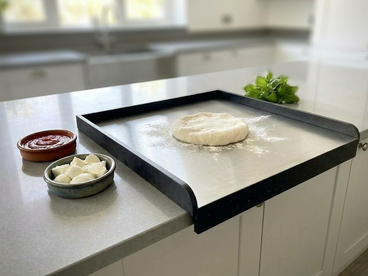 Stendì hooked over the edge of a kitchen island, with dough, sauce and mozzarella
